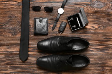Ahşap arka planda erkek ayakkabıları ve aksesuarlar.