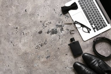 Gri grunge arka planda dizüstü bilgisayarı, ayakkabısı ve papyonu olan erkek aksesuarları. Üst görünüm