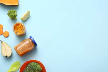 Sağlıklı bebek püresi kavanozları ve renk arkaplan malzemeleriyle kompozisyon