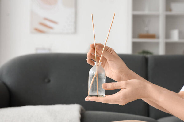 Female hands with aroma diffuser at home, closeup