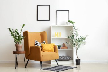 Rahat koltuğu, kahve masası ve zeytin ağacı olan şık bir oturma odası.