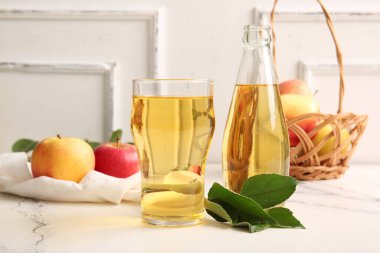 Meyveli kompozisyon, hasır sepet, şişe ve masada taze elma şarabı.