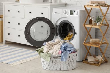 Çamaşır makinası ve kirli çamaşırlarla dolu sepet.
