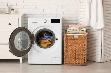 Çamaşır odasında kirli çamaşırları olan modern çamaşır makinesi.