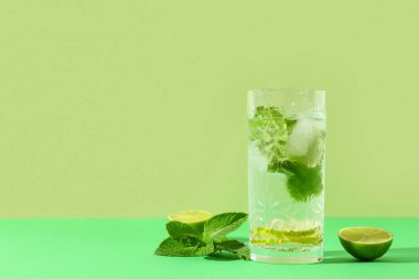 Yeşil arka planda naneli ve limonlu taze mojito.