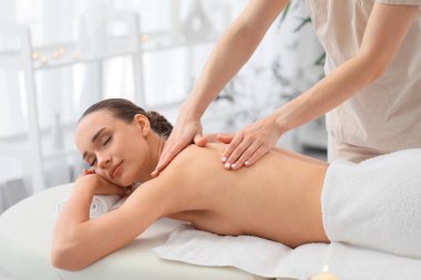 Kaplıca salonunda masaj yaptıran genç bir kadın