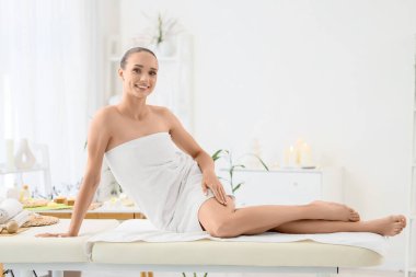 Masaj sonrası kanepede oturan genç bir kadın.