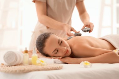 Sıcak taş terapisi spa salonda geçiren genç kadın