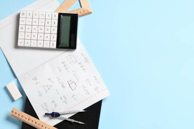 El yazısıyla yazılmış matematik formülleri ve mavi arkaplanda kırtasiye defteri