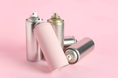 Pembe arka planda sprey boya kutuları