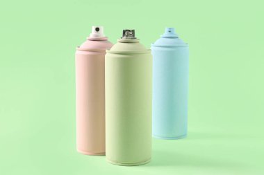 Yeşil arka planda sprey boya kutuları