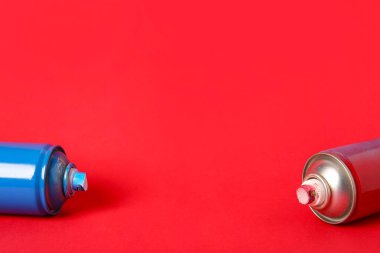 Kırmızı arkaplanda sprey boya kutuları