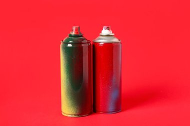 Kırmızı arkaplanda sprey boya kutuları