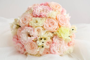 Güzel düğün buketi ve açık arkaplanda gelin peçesi.