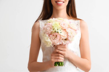 Beyaz arka planda güzel bir düğün buketi olan gelin