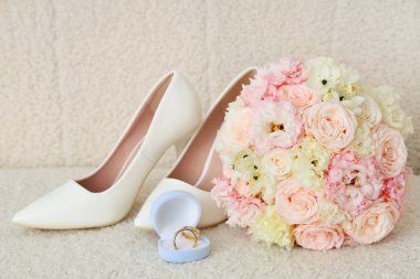 Güzel bir düğün buketi, açık arkaplanda ayakkabı ve yüzükler