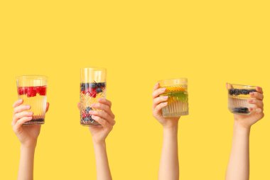 Sarı zemin üzerinde aşılanmış su olan birçok el