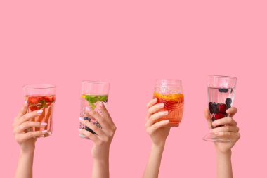 Pembe arka planda erimiş su olan birçok el