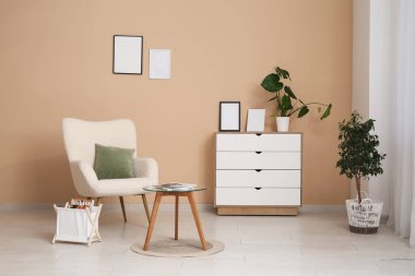 Koltuk, kahve masası, dergi ve çekmeceler oturma odasında.