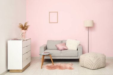 Sıcak kanepe, çekmeceler, sehpa ve puf oturma odasında.