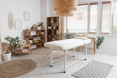 Kanepesi, masası ve raf ünitesi olan bir kaplıca salonu.