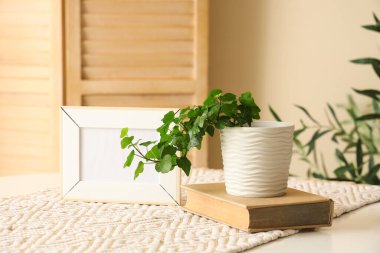 Boş çerçeve, kitap ve bitki yemek masasında, yakın plan.