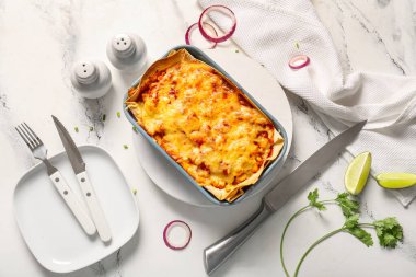 Hafif arka planda lezzetli enchilada, baharat ve çatal bıçak ile kompozisyon