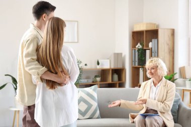 Psikologların ofisinde sarılan genç bir çift.