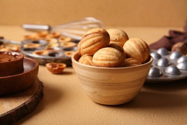 Lezzetli ceviz şekilli kurabiyeler ve renk arkaplanda pişirme biçimi olan kase