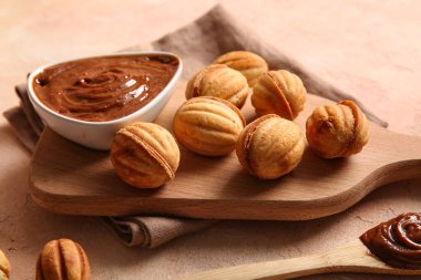 Lezzetli ceviz şekilli kurabiyelerle ahşap tahta tahta ve renkli masada haşlanmış süt.