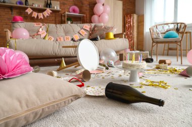 Doğum günü pastası, dağınık oturma odasında halıda parti dekorasyonu.