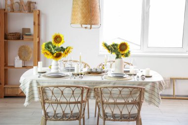 Oda da güzel ayçiçekleri olan yemek masası servis edildi.