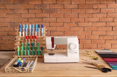 Atölyede dikiş makinesi ve iplik makaralarıyla terzinin işyeri