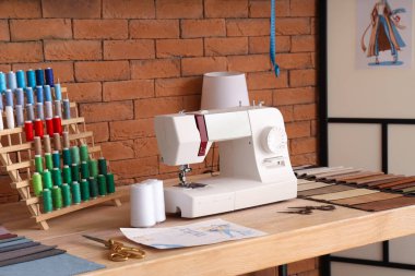Atölyede dikiş makinesi ve iplik makaralarıyla terzinin işyeri