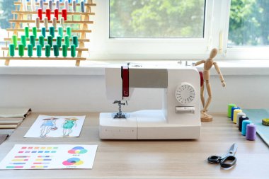 Atölyedeki masada terzi malzemeleri olan dikiş makinesi.