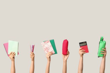 Beyaz arkaplanda farklı kırtasiye malzemesi olan kadın elleri