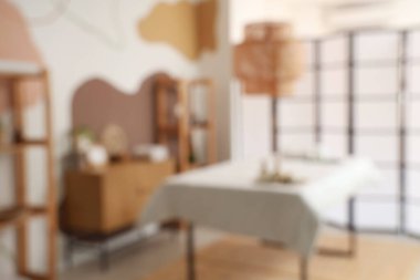 Kanepesi, rafları ve katlanan ekranı olan modern spa salonunun bulanık görüntüsü