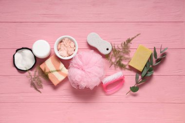 Farklı banyo malzemelerine sahip kompozisyon ve renkli ahşap arka planda bitki dalları