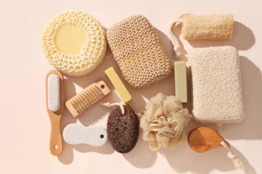 Farklı banyo süngerleri, masaj fırçaları ve renk arkaplanlı sabun içeren kompozisyon