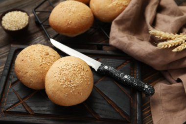 Tahta zemin üzerinde susam tohumları olan taze çörekler.