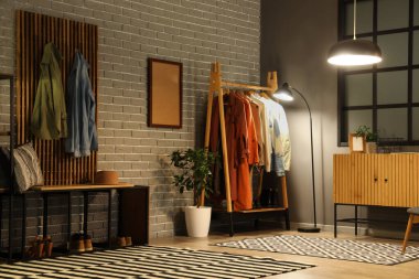 Parlak lambalar ve palto askısı olan salonun içinde.