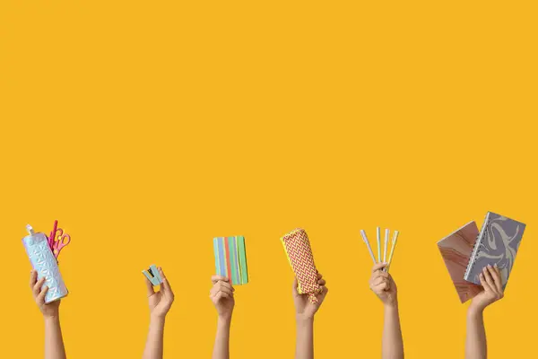 stock image Female hands with different school supplies on yellow background