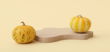 Bej arkaplanda dekoratif podyum ve balkabakları 