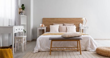 Büyük yataklı, banklı ve masalı, aydınlık, modern yatak odası.