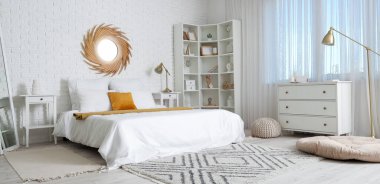 Büyük yataklı, aynalı ve raflı aydınlık yatak odasının içi.