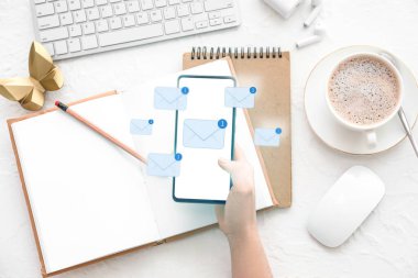 İş yerindeki e-postaları kontrol etmek için akıllı telefon kullanan kadın, üst görünüm