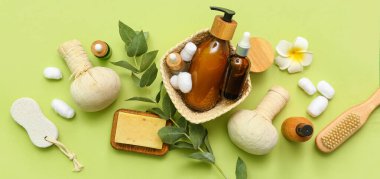 Kozmetik ürünleri, spa aksesuarları ve yeşil arka planda okaliptüs dalıyla kompozisyon
