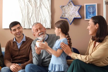 Hanuka bayramını evde donutlarıyla kutlayan mutlu Yahudi bir aile.