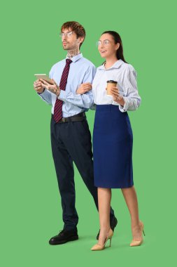 Gözlüklü, tabletli ve yeşil arka planda kahve fincanı olan iş adamları.