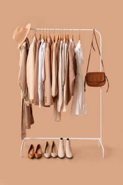 Bej arka planda şık kıyafetlerle dizin